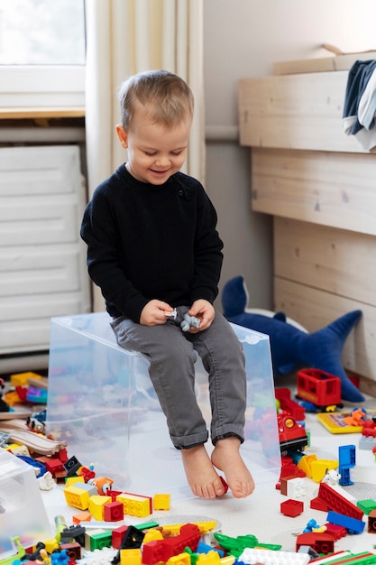 Enfant plein coup assis sur un conteneur