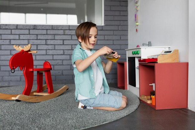 Enfant plein coup assis sur un tapis