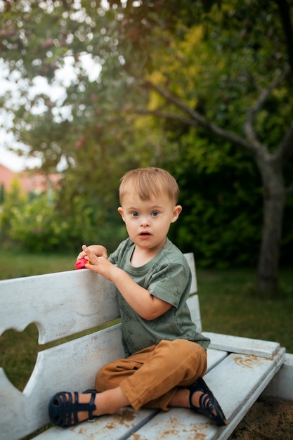 Photo gratuite enfant plein coup sur banc jouant