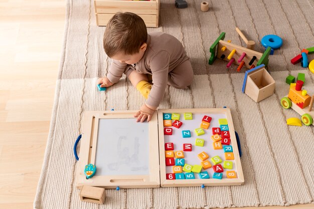 Enfant plein coup jouant avec des jouets en bois colorés