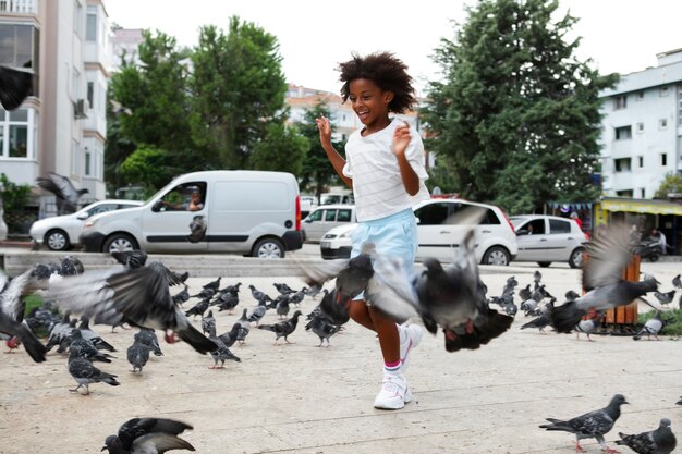 Enfant plein coup jouant avec des pigeons