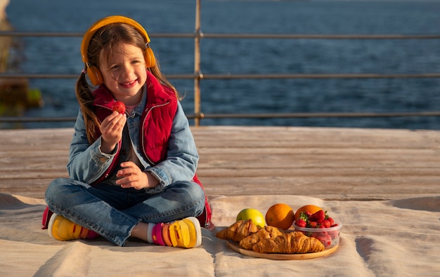 Photo gratuite enfant plein coup avec de la nourriture sur une jetée