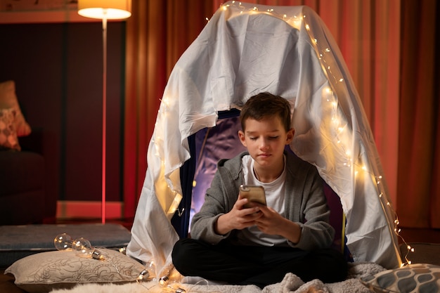 Photo gratuite enfant plein coup tenant un smartphone