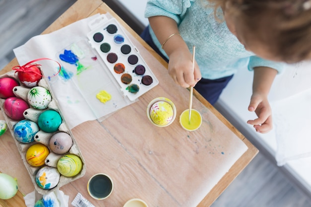 Enfant prenant une peinture jaune pour oeuf