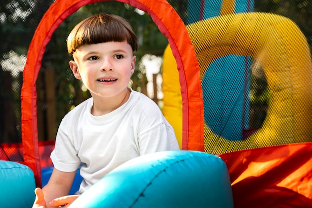 Photo gratuite enfant s'amusant dans la vue latérale de la maison de rebond