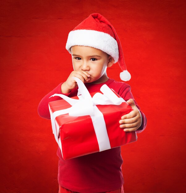 Enfant avec santa cap toucher sa bouche