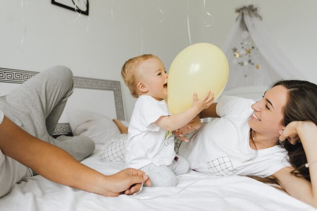 L&#39;enfant se réjouit dans le ballon avec ses parents