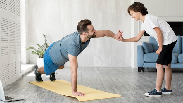 Enfant et son père faisant du sport à la maison