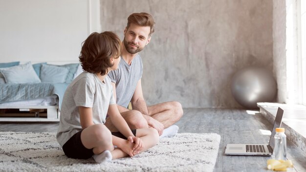 Enfant et son père faisant du sport à la maison