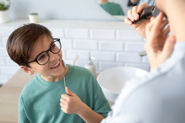 Enfant souriant à angle élevé tenant une cuillère