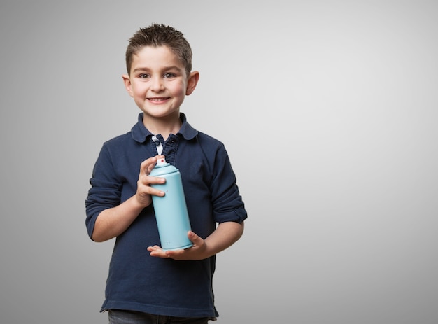 Enfant souriant avec une bombe aérosol