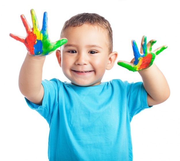 Enfant souriant avec les mains pleines de peinture