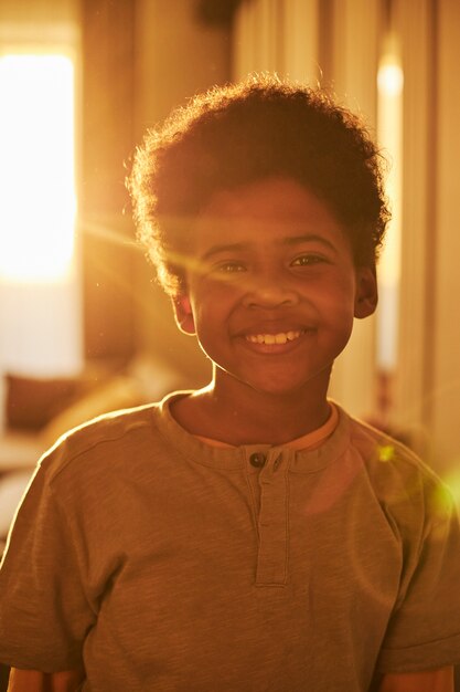 Enfant souriant de plan moyen à la maison