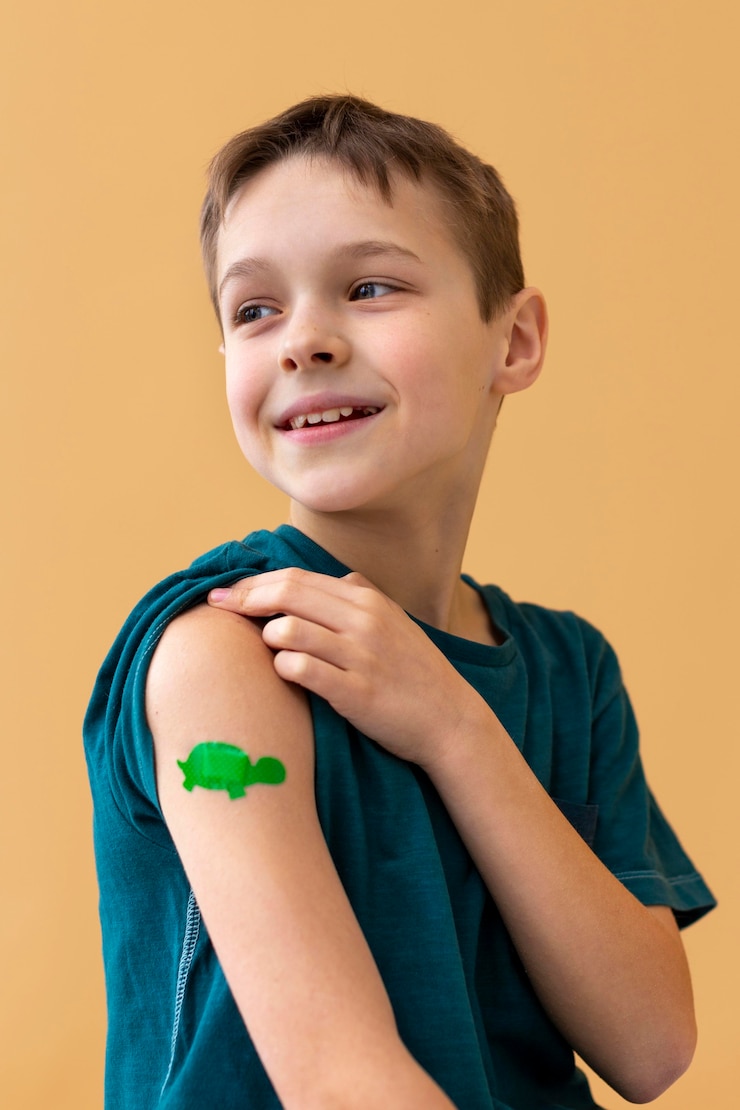 Photo gratuit enfant souriant à plan moyen portant un pansement