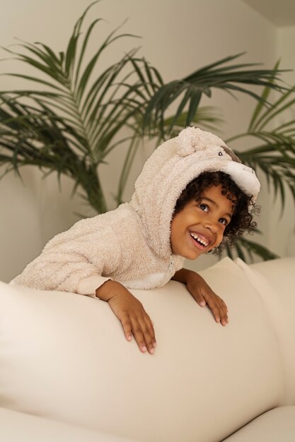 Enfant souriant vue de côté à la maison