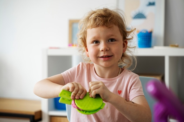 Enfant souriant vue de face avec jouet