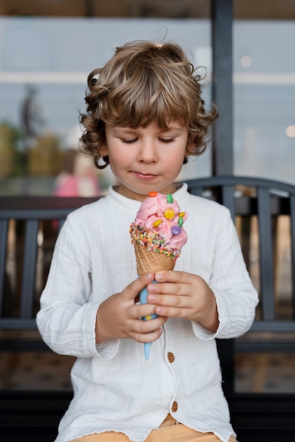 Enfant souriant vue de face regardant la crème glacée