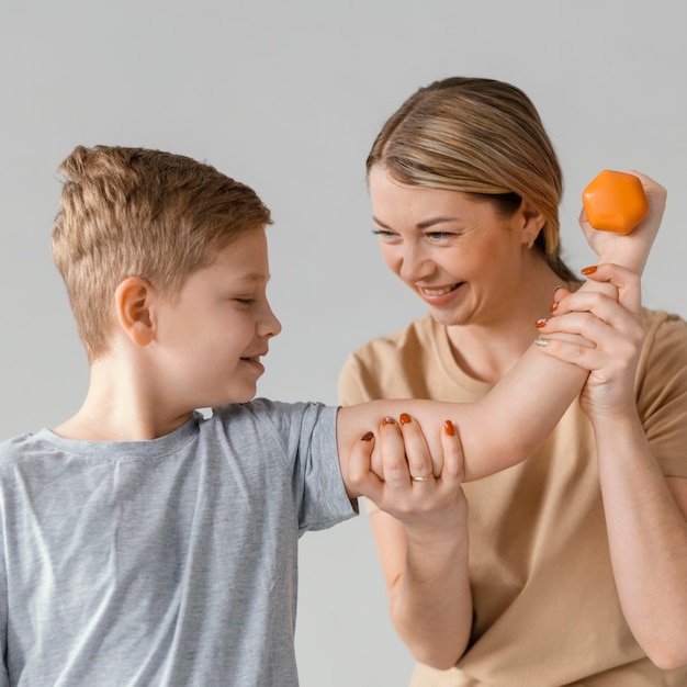 Enfant de tir moyen exerçant avec haltère