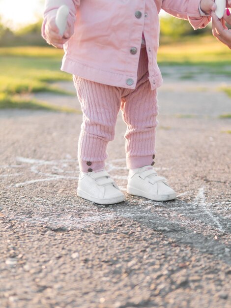 Enfant en vêtements roses debout sur un sol solide