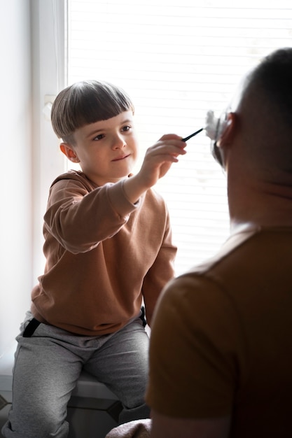 Photo gratuite enfant vue de côté aidant l'homme à se raser