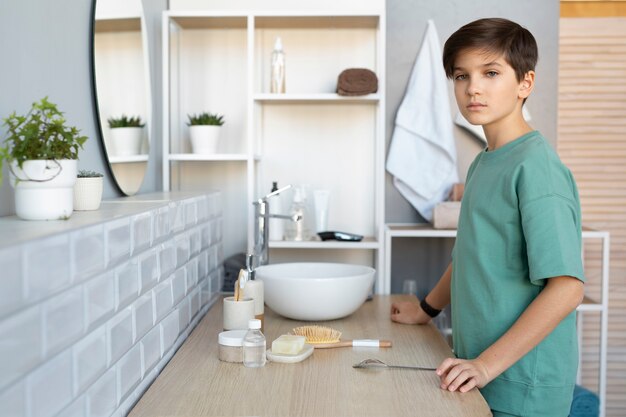 Enfant vue de côté debout dans la salle de bain