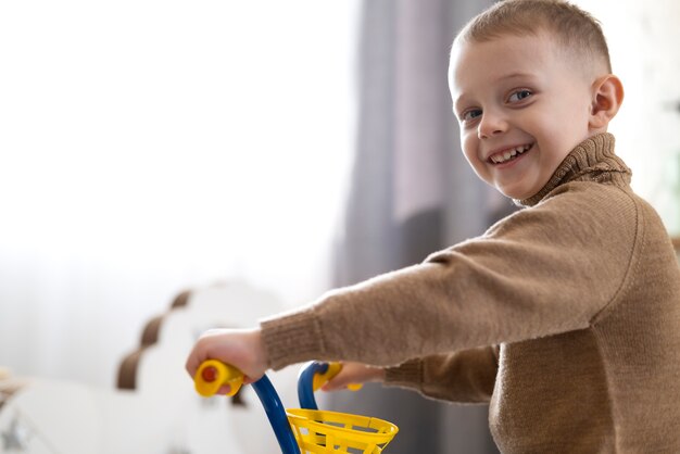 Enfant vue de côté tenant le guidon du tricycle