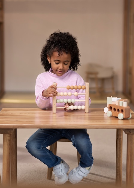 Photo gratuite enfant vue de face assis à table