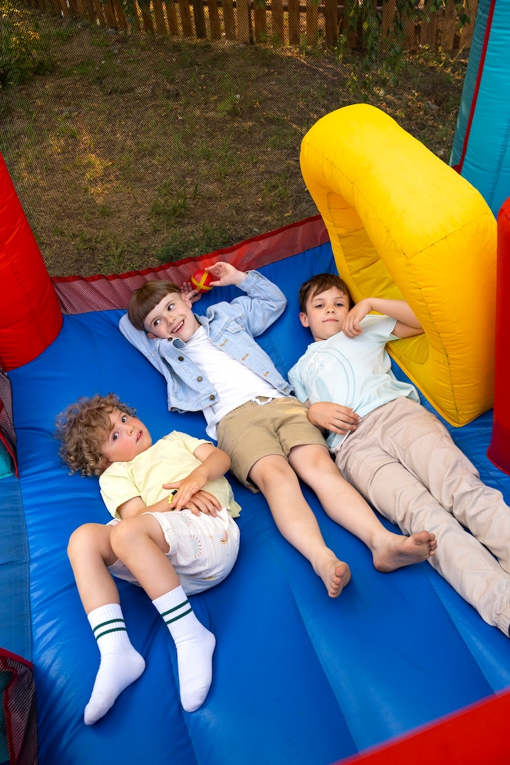 Photo gratuit enfants à angle élevé allongés dans une maison de rebond