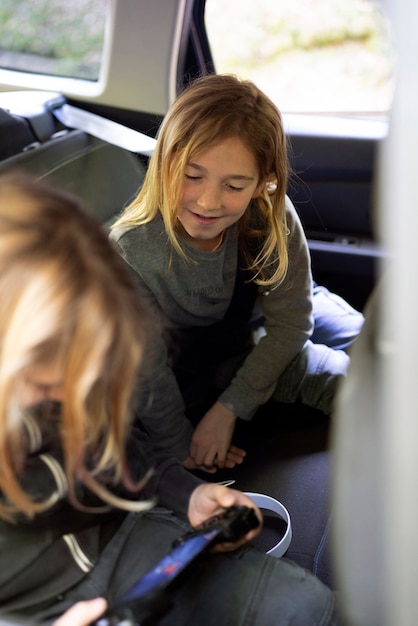 Photo gratuite enfants à angle élevé jouant dans la voiture