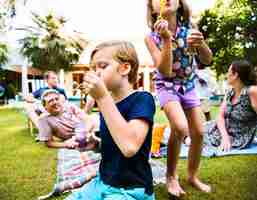 Photo gratuite enfants appréciant souffler des bulles à l'extérieur