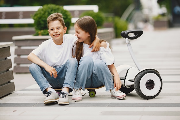 Photo gratuite les enfants apprennent à faire du hoverboard dans un parc aux beaux jours d'été