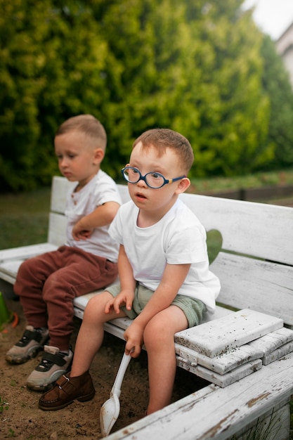 Enfants assis sur un banc vue de côté