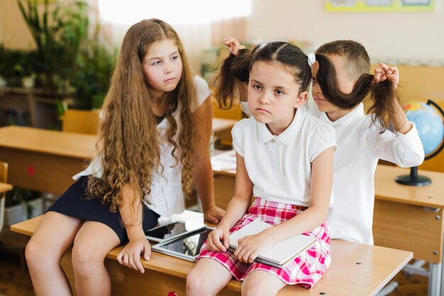 Enfants assis sur un bureau en salle de classe