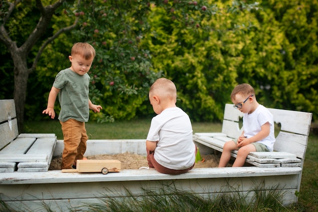 Photo gratuite enfants assis dehors plein coup