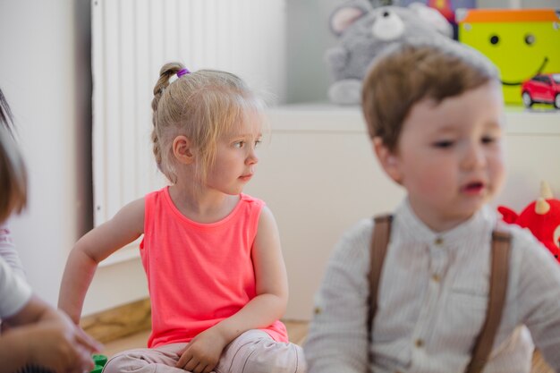 Enfants assis sur le sol dans la salle de jeux