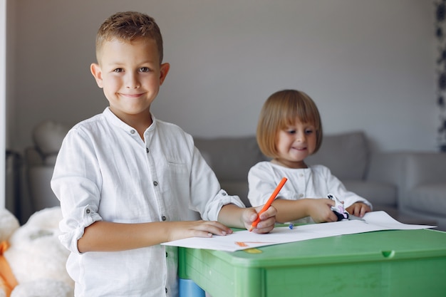 Enfants Assis à La Table Verte Et Dessinant