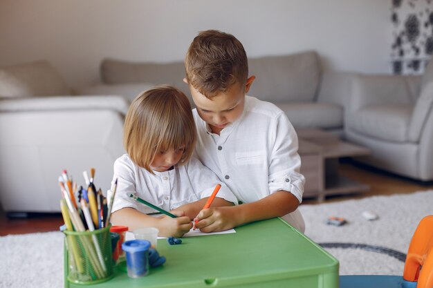 Enfants assis à la table verte et dessinant