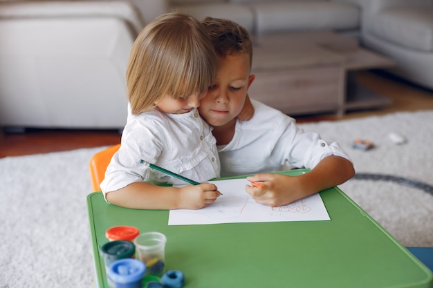 Enfants assis à la table verte et dessinant