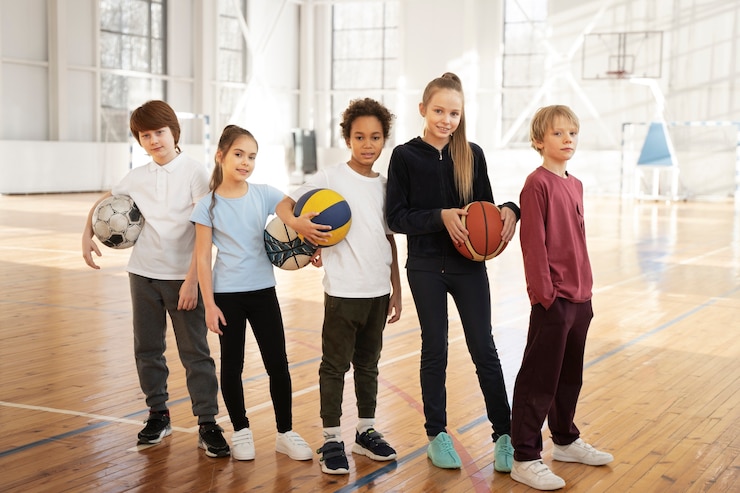 Photo gratuit des enfants avec des balles au gymnase.