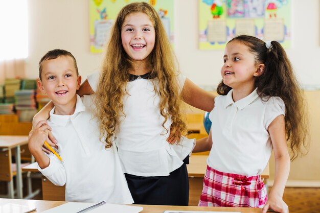 Les enfants en blouse blanche posant des sourires