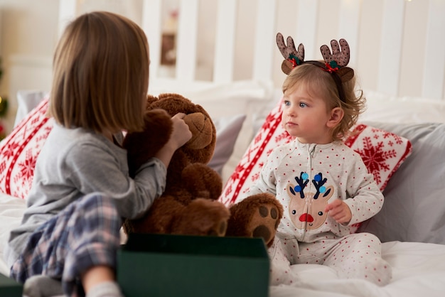 Enfants avec cadeau dans le lit