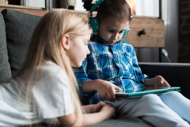 Enfants sur le canapé avec tablette