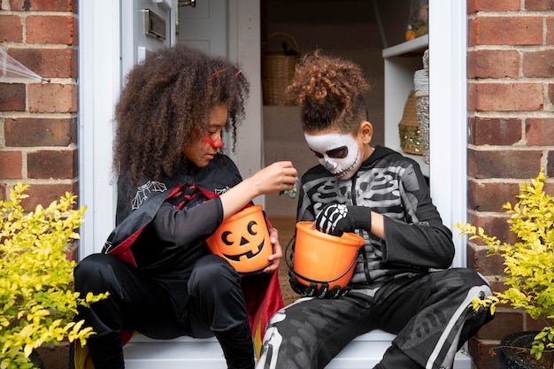 Photo gratuite enfants en costumes mangeant leurs bonbons