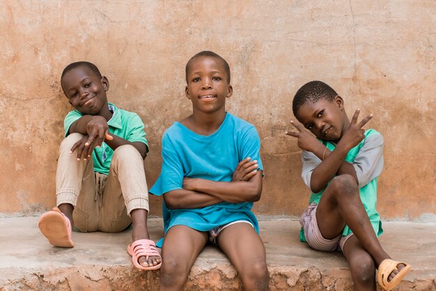 Enfants coup moyen assis à l'extérieur