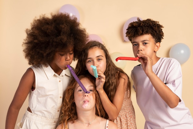 Photo gratuite enfants de coup moyen avec des sifflets de fête