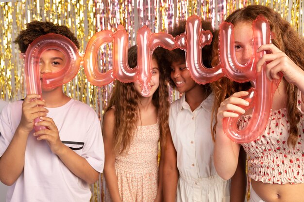 Enfants de coup moyen tenant des ballons