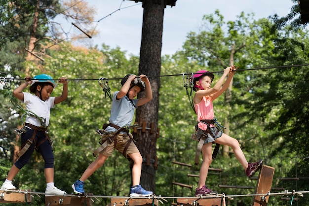 Enfants courageux jouant dans un parc d'aventure