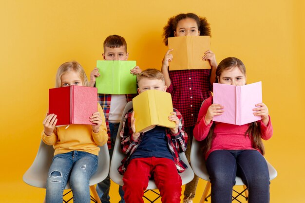 Enfants couvrant les visages avec des livres