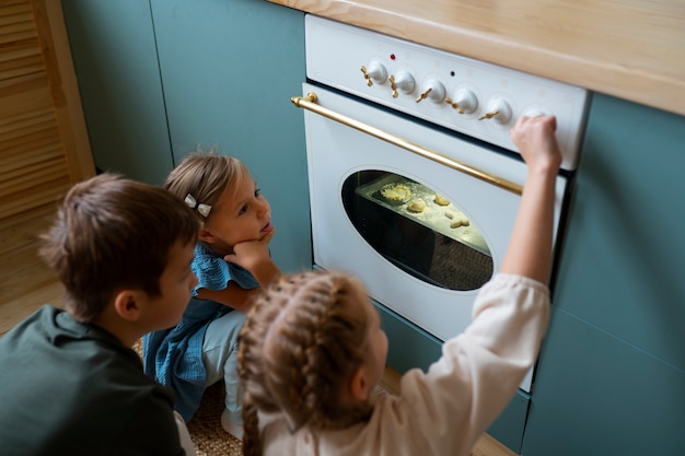 Photo gratuite enfants cuisinant des biscuits à angle élevé