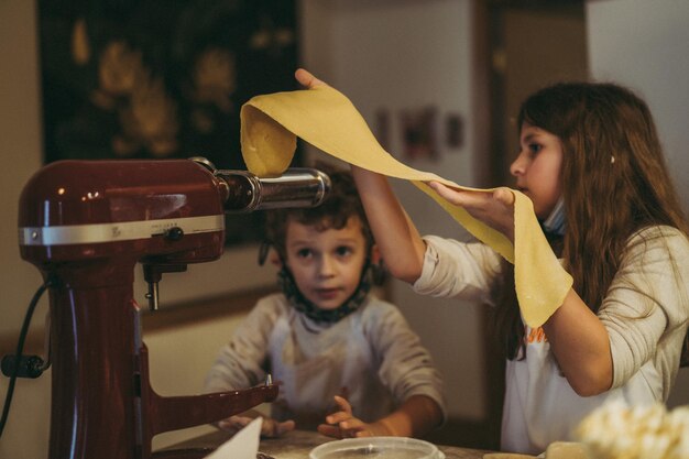 les enfants cuisinent des pâtes lors d'une master class de gastronomie